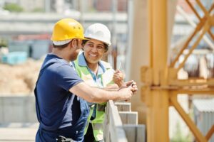 Two construction workers in hi-vis reviewing plans on site